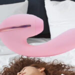 A Kistoys Tina clitoral stimulation toy displayed on a bed background